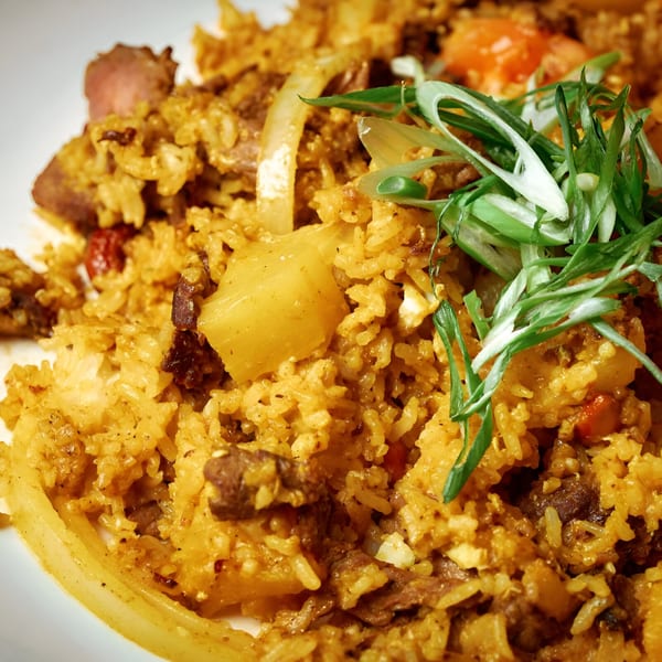 Close-up of Pink Basil's pineapple fried rice with meat, vegetables, and green onions.
